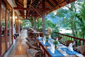 un ristorante con tavoli e sedie su un balcone di Riverside Boutique Resort, Vang Vieng a Vang Vieng Altre 48 foto