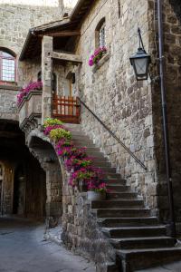 un edificio in pietra con scale e fiori di Il Peperino GuestHouse a Viterbo