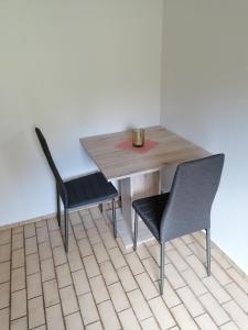 einen Tisch und zwei Stühle in einem Zimmer mit einem Tisch in der Unterkunft Landhaus Dahlem in Hahnenklee-Bockswiese