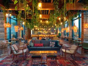 een lobby met een bank en stoelen en een bar bij Treehouse Hotel London in Londen