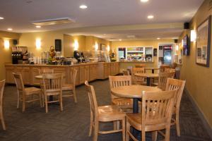 a restaurant with wooden tables and chairs and a counter at Bayside Resort Hotel in West Yarmouth