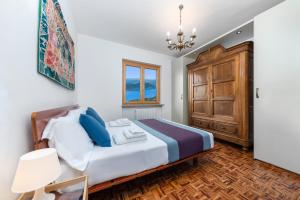 a bedroom with a bed and a wooden cabinet at Villa Regina Bella by Casa da Suite in Nebbiuno