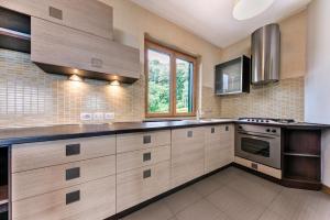 a kitchen with wooden cabinets and a stove top oven at Villa Regina Bella by Casa da Suite in Nebbiuno