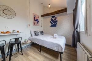 a small bedroom with a bed and a table at Apartments WS Saint-Lazare - Lafayette in Paris