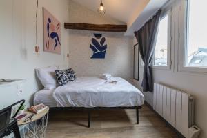 a small bedroom with a bed and a window at Apartments WS Saint-Lazare - Lafayette in Paris