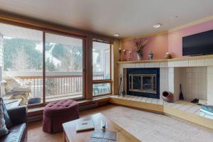 a living room with a fireplace and a tv at Liftside Condominiums 203 in Keystone