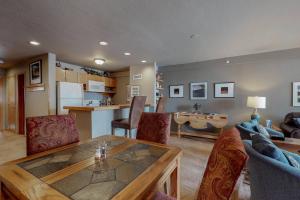 a living room with a table and chairs and a kitchen at Liftside Condominiums 203 in Keystone