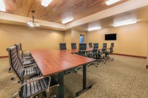 a conference room with a large wooden table and chairs at Clarion Hotel & Suites Williston in Williston