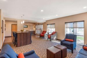 ein Wohnzimmer mit blauen Möbeln und eine Küche in der Unterkunft Comfort Inn & Suites near Route 66 in Lincoln