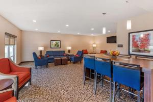 ein Hotelzimmer mit einer Bar und einem Wohnzimmer in der Unterkunft Comfort Inn & Suites near Route 66 in Lincoln