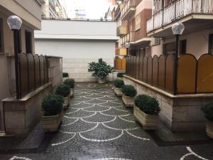 une cour avec des plantes en pot sur le côté d'un bâtiment dans l'établissement Pigneto Guest House, à Rome