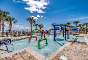 a swimming pool with a pool table and chairs at Dunes Village in Myrtle Beach