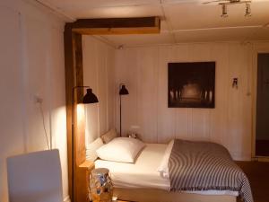 Un dormitorio con una cama y una lámpara. en B&B Bären en Rüeggisberg