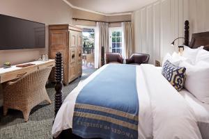 a hotel room with a bed and a desk and a television at L'Auberge De Sedona in Sedona