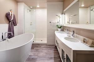 bagno con 2 lavandini, vasca e doccia di L'Auberge De Sedona a Sedona
