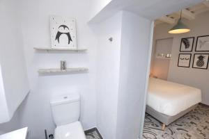 a small bathroom with a toilet and a bed at CASA COCO in Vejer de la Frontera