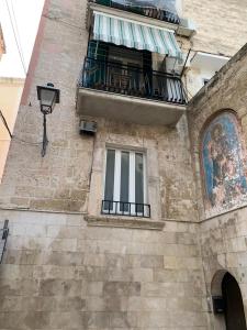 ein Gebäude mit einem Balkon und einem Fenster in der Unterkunft Residenza San Marco Dei Veneziani in Bari