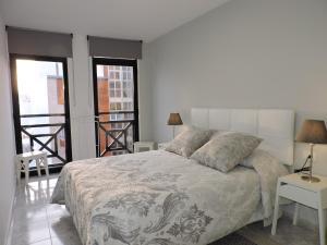 a bedroom with a large bed and a balcony at Casas Insel, apartamentos en el centro de Los Llanos in Los Llanos de Aridane