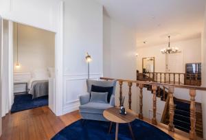 a living room with a chair and a bedroom at CASA DA GRAÇA in Ponta Delgada