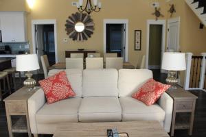 a living room with a white couch with red pillows at Beacon Villas at Corolla Light Resort by KEES Vacations in Corolla