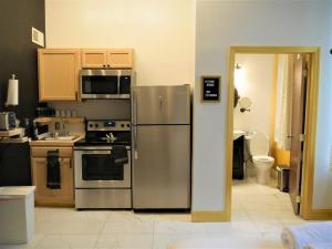 cocina con nevera de acero inoxidable y fogones en Stay Pittsburgh en Pittsburgh