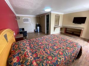 Un dormitorio con una cama con una colcha colorida. en Economy Inn, en Arcadia