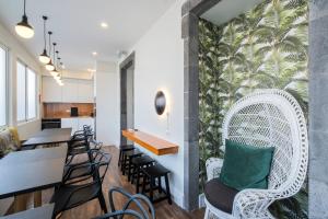 a dining room with a white rattan chair and a table at CASA DA GRAÇA in Ponta Delgada