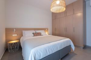 een slaapkamer met een groot wit bed en een lamp bij Sea and City Luxurious Apartment in Kos-stad