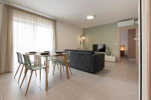 een woonkamer met een tafel en stoelen en een bank bij Sea and City Luxurious Apartment in Kos-stad