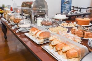 uma linha de buffet com diferentes tipos de pão e pastelaria em Pousada Colonial Chile em Salvador