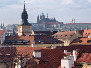 vista su una città con torre dell'orologio e tetti di Liliova Apartments a Praga
