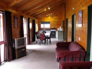 un soggiorno con divano e TV di Alpine Cabin - Ohakune Holiday Home a Ohakune