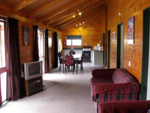 a living room with a couch and a tv at Alpine Cabin - Ohakune Holiday Home in Ohakune