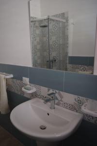 a bathroom with a sink and a mirror and a toilet at Appartamenti AcquaChiara in San Vito lo Capo
