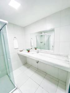 a white bathroom with a sink and a mirror at Pousada Colonial Chile in Salvador