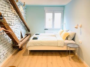 een slaapkamer met een bed en een bakstenen muur bij Rainbow Central Studio by Carpe Diem in Zagreb