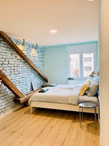 een slaapkamer met een bed en een bakstenen muur bij Rainbow Central Studio by Carpe Diem in Zagreb