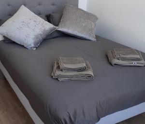 uma cama com almofadas e toalhas por cima em Grande Marina Vue Port em Deauville