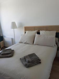 uma cama branca com duas toalhas em cima em Grande Marina Vue Port em Deauville