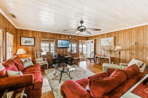 a living room with a couch and a ceiling fan at Clervue Cottage in Folly Beach