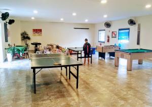 a man standing in a room with ping pong tables at Hotel Litoral Norte in Caraguatatuba