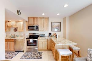een keuken met houten kasten en roestvrijstalen apparatuur bij Jarvis #202 in Durango