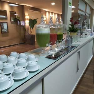 a counter with cups and saucers on top at Maximus Business Hotel in Ji-Paraná