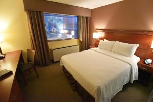a hotel room with a large bed and a window at Canad Inns Destination Center Grand Forks in Grand Forks