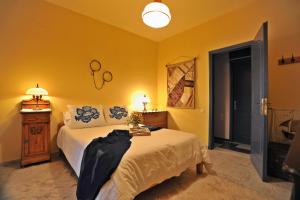 a bedroom with a bed and a yellow wall at Studio Maistros in Galaxidi