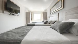 Cette chambre comprend 4 lits et une télévision à écran plat. dans l'établissement Danieri Asunción Hotel, à Asuncion