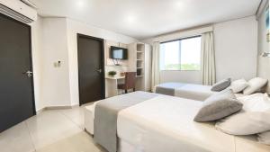 Ліжко або ліжка в номері Danieri Asunción Hotel