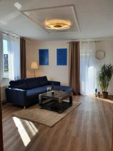 uma sala de estar com um sofá azul e uma mesa de centro em Müller´s Ferienwohnung em Neuhof