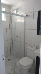 a bathroom with a toilet and a glass shower at Hotel Rainha in Itapoa