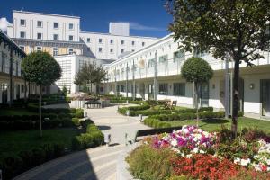 einen Innenhof eines Gebäudes mit Blumen und Pflanzen in der Unterkunft Corinthia Budapest in Budapest